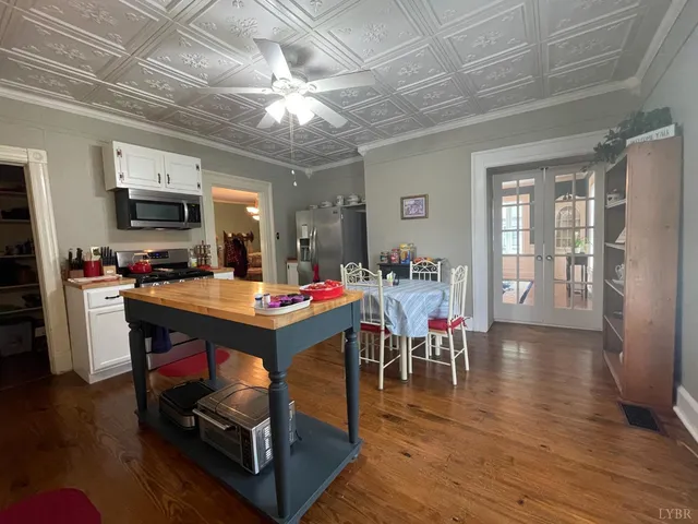 a view of a dining room with furniture a chandelier and wooden floor