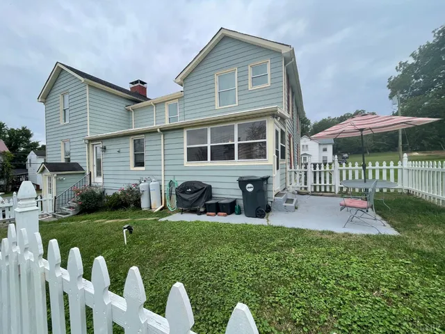 a view of a house with a yard and a fence