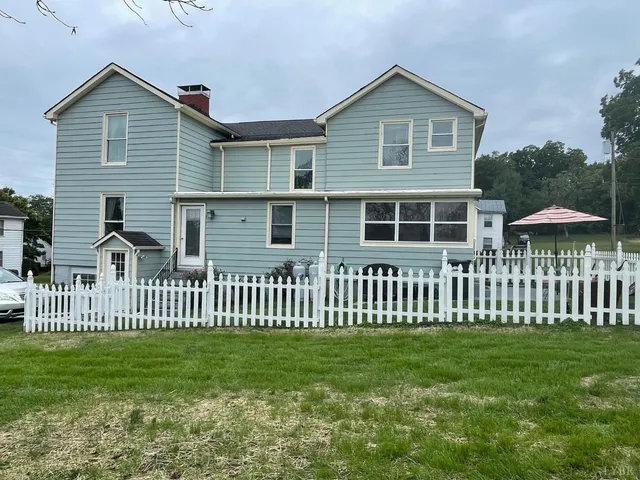 a view of a livingroom with furniture window wooden floor and front door