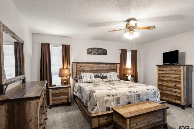 a bathroom with a granite countertop sink a toilet and shower