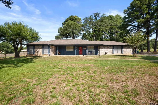 a view of a house with backyard and a tree