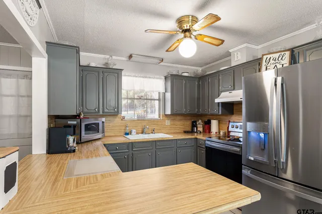 a kitchen with kitchen island granite countertop a sink stainless steel appliances and cabinets