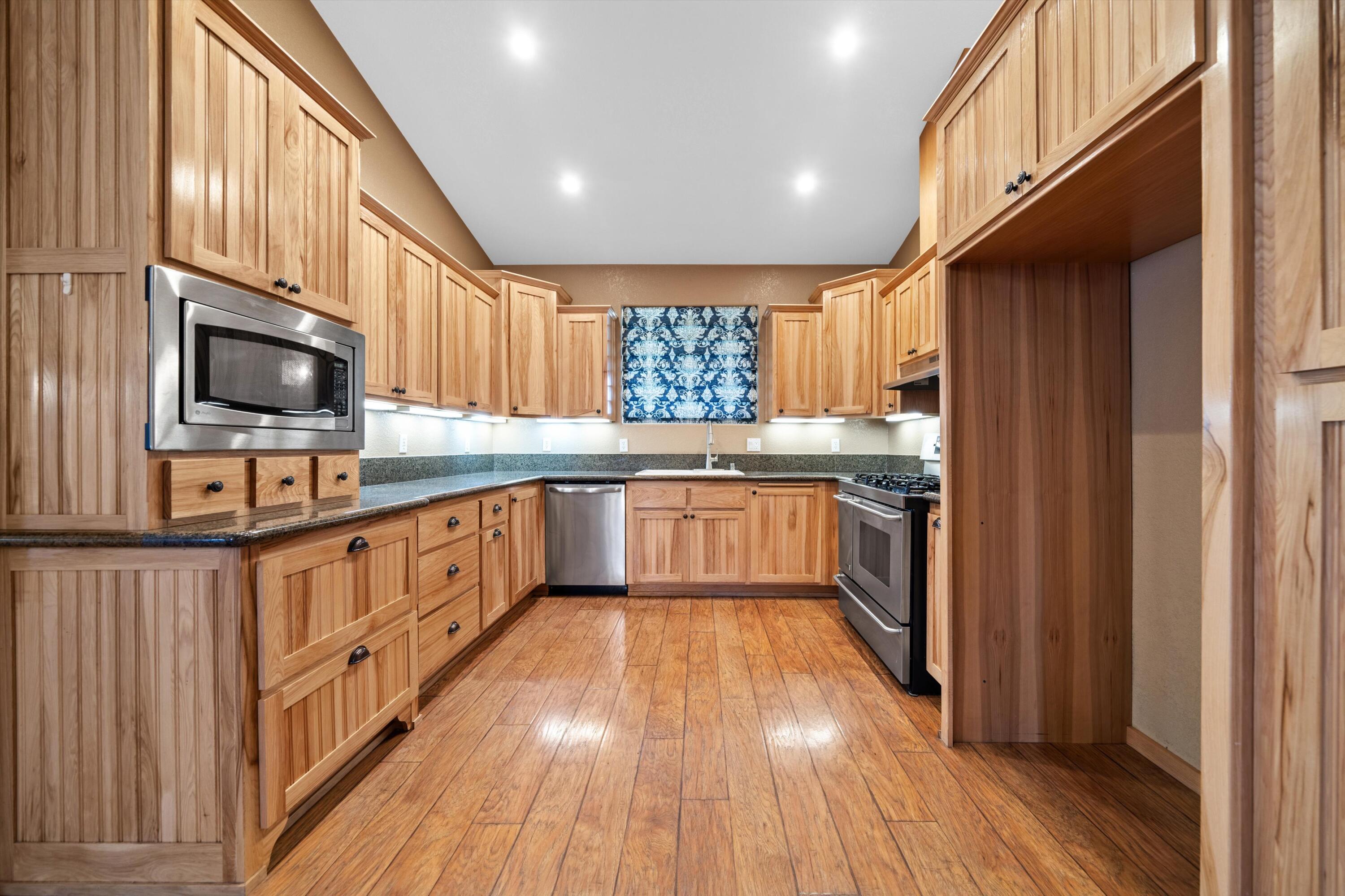 28321 Pimlico Way Tehachapi, CA 93561 - Photo 19 of 23 a kitchen with a sink wooden floor stainless steel appliances and a window