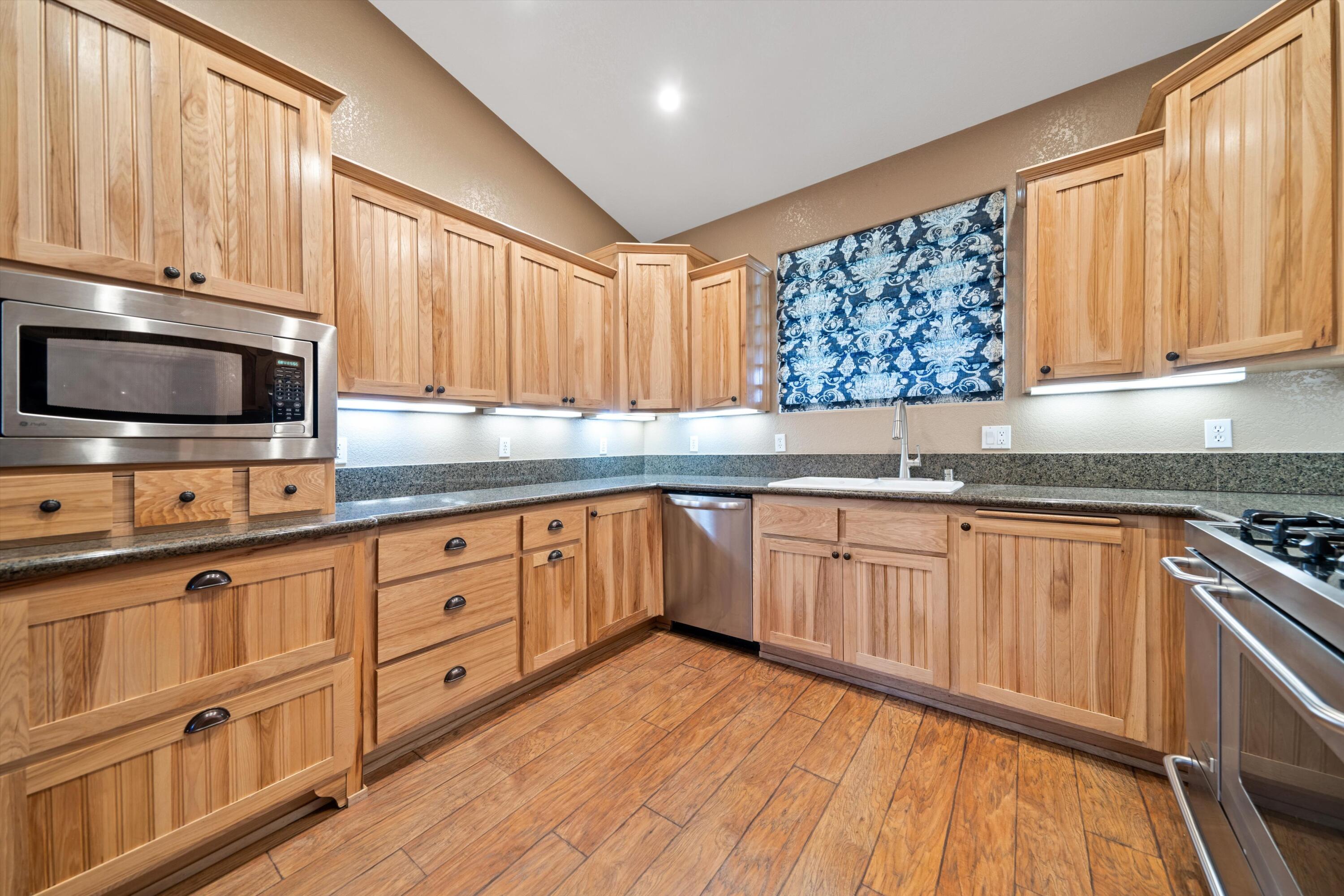 28321 Pimlico Way Tehachapi, CA 93561 - Photo 20 of 23 a kitchen with granite countertop wooden cabinets a sink and a stove