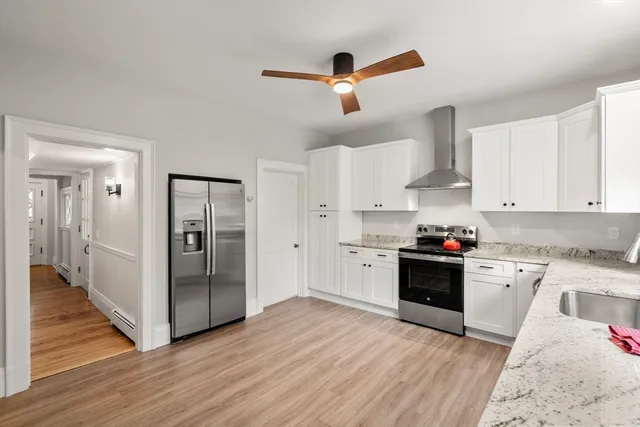 a kitchen with granite countertop white cabinets a sink a window and stainless steel appliances