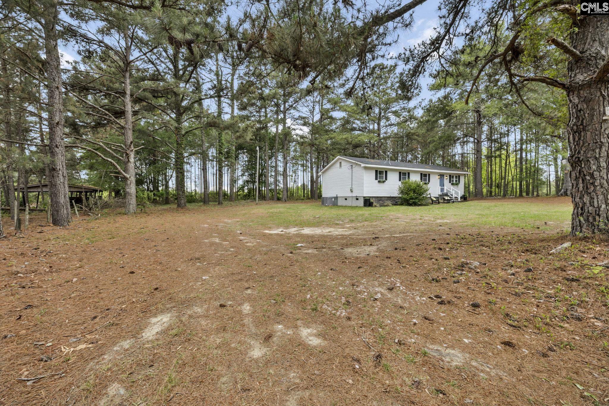 8107 Black River Road Rembert, SC 29128 - Photo 37 of 38 a view of a field with trees in front of house