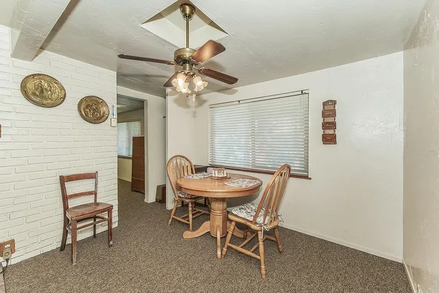 a dining room with furniture and a clock fan