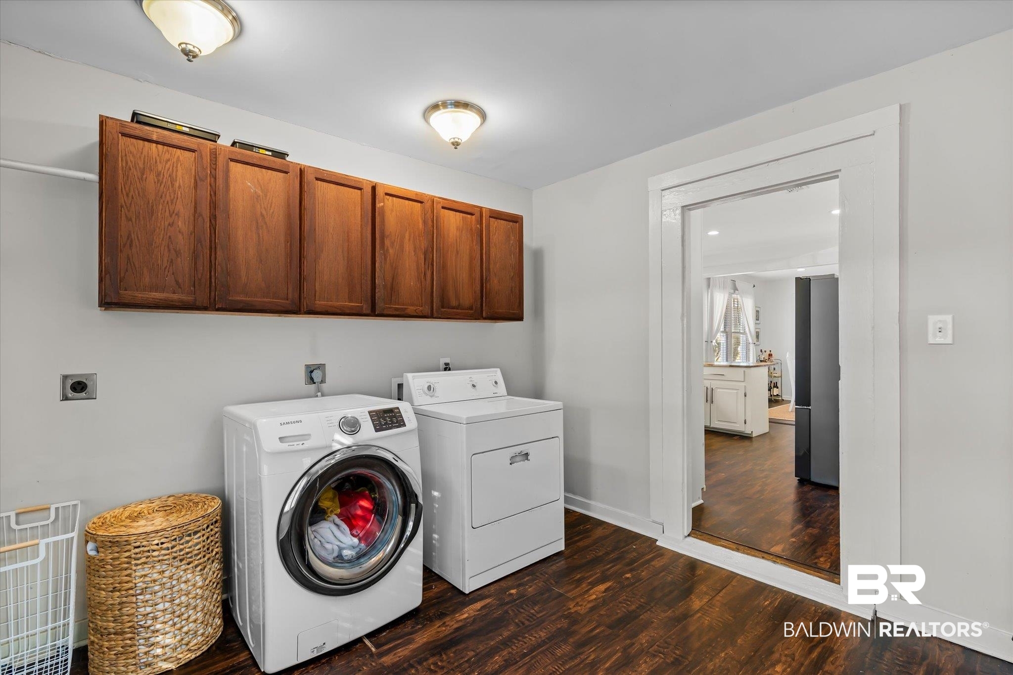 180 Williams Street Mobile, AL 36606 - Photo 17 of 20 Washroom with hookup for an electric dryer, cabinets, dark wood-type flooring, and hookup for a washing machine
