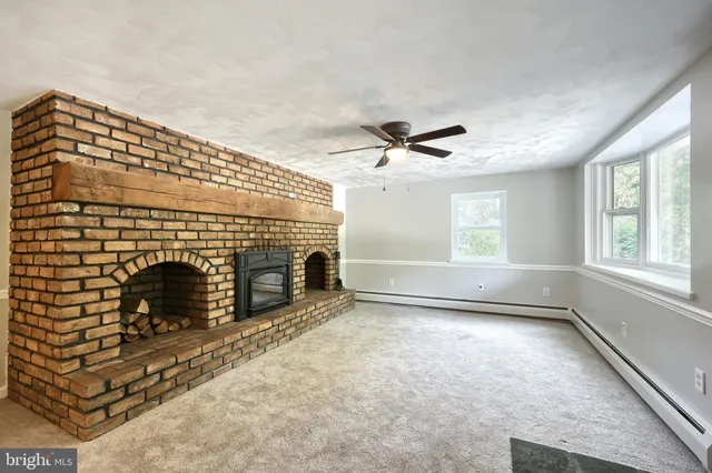a view of empty room with fireplace and fan