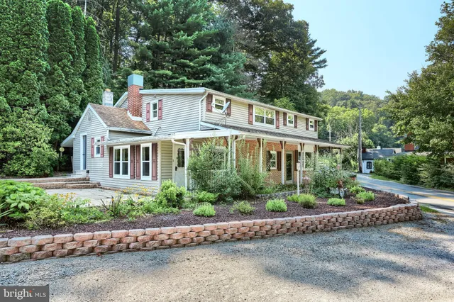 a front view of a house with a yard and a garden