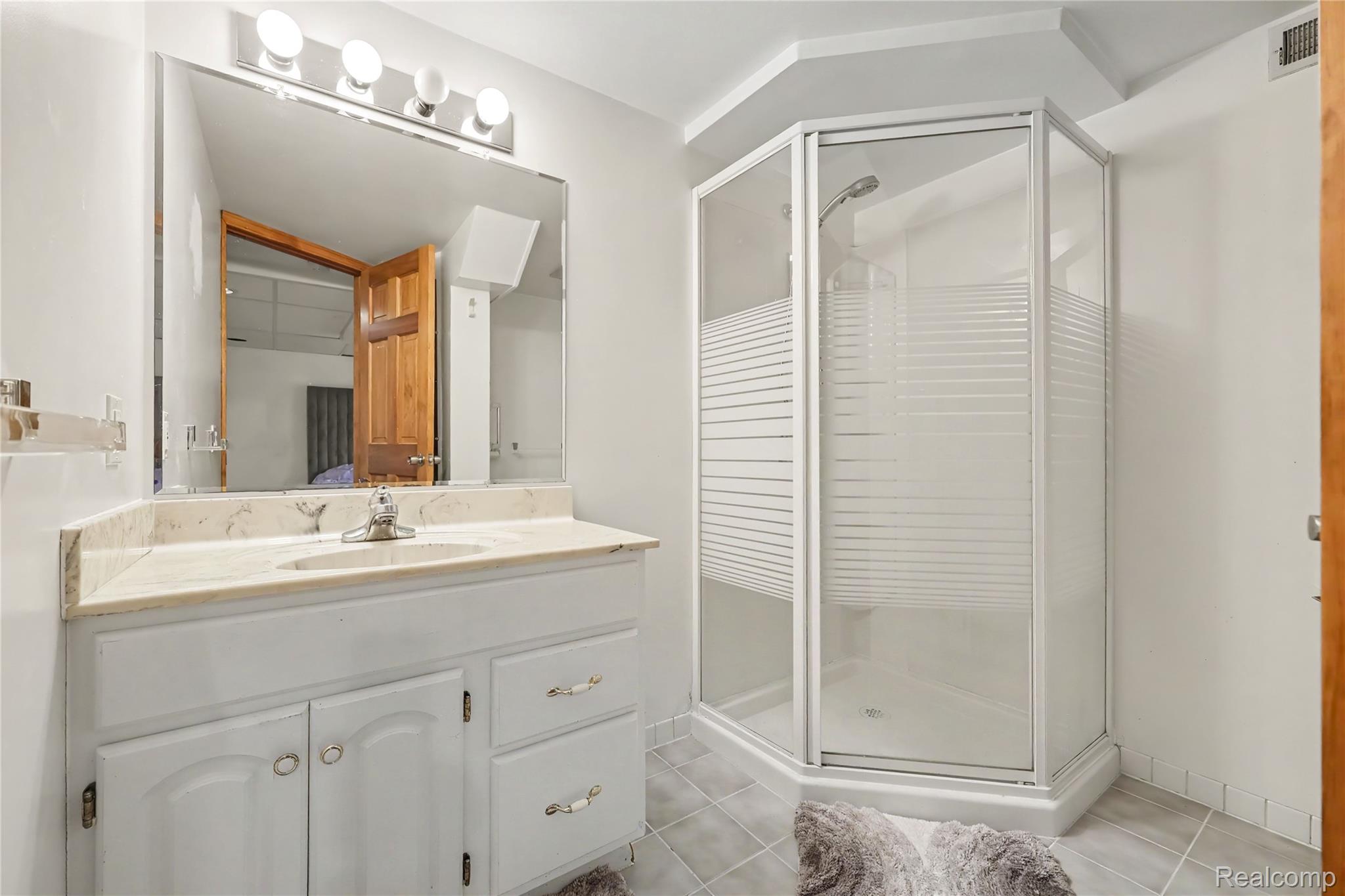 412 Meadow Bridge Drive Rochester, MI 48307 - Photo 16 of 23 White vanity with light-colored countertop, undermount sink, and chrome faucet