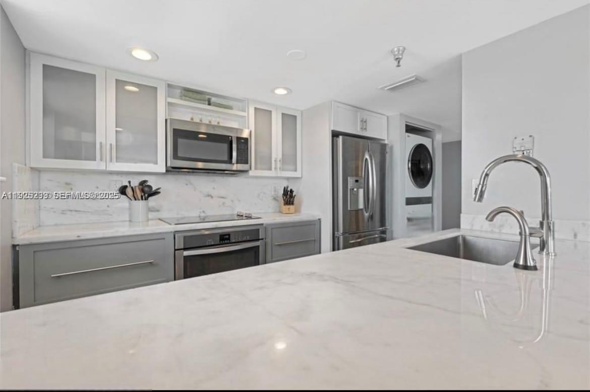 2400 Southwest 3rd Avenue, Unit 802 Miami, FL 33129 - Photo 2 of 12 a kitchen with stainless steel appliances granite countertop a sink a stove a microwave and a refrigerator
