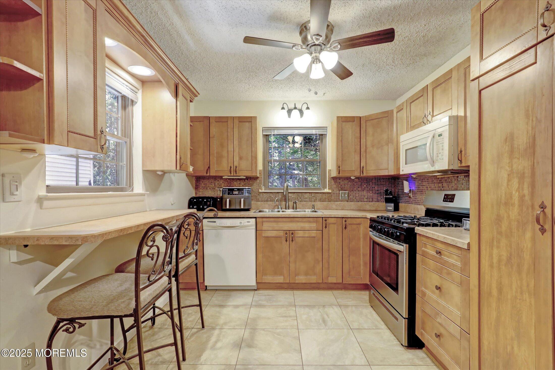 95 Azalea Circle Jackson, NJ 08527 - Photo 11 of 38 a kitchen with stainless steel appliances granite countertop a stove top oven a sink a dining table and chairs