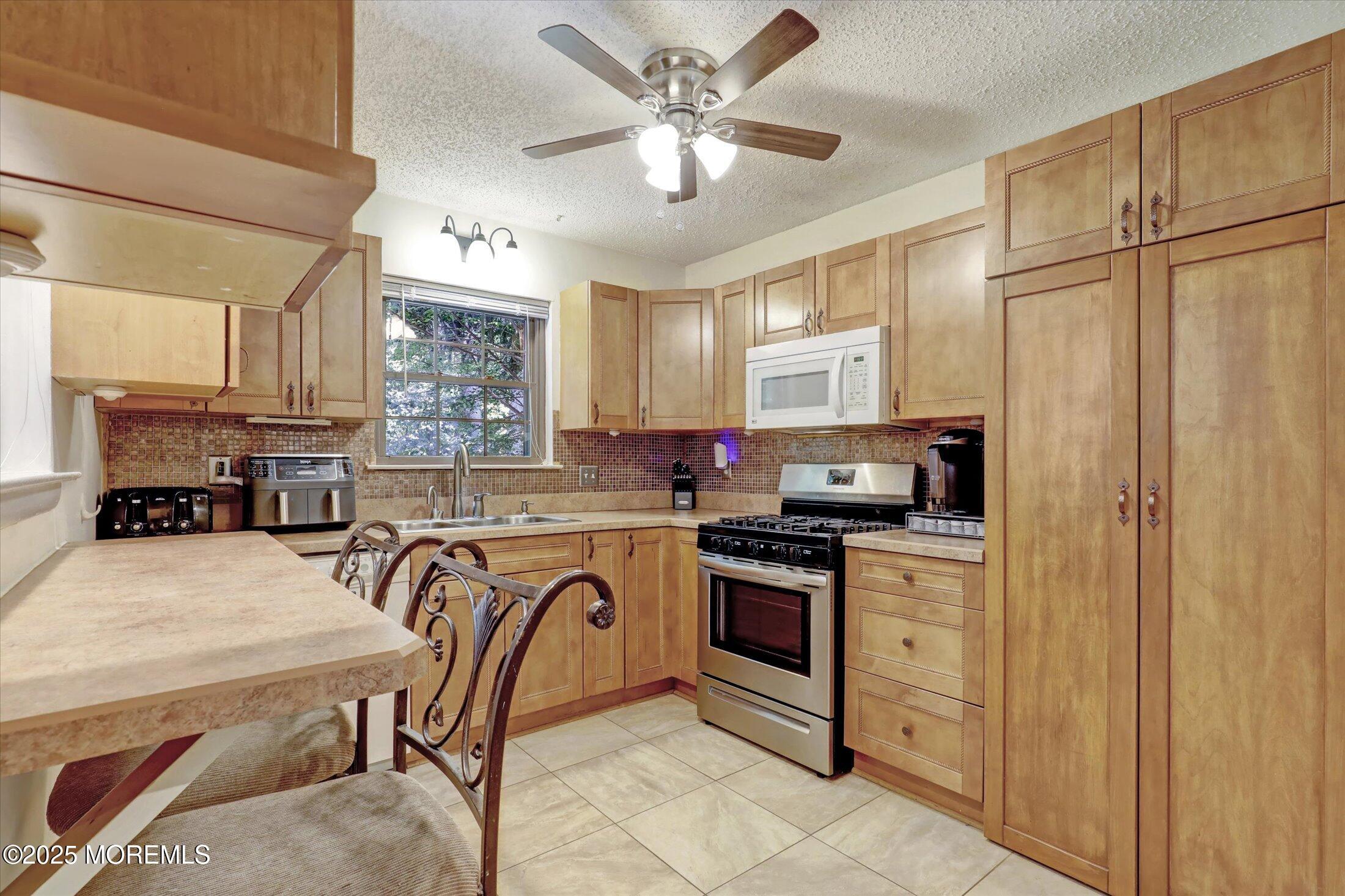 95 Azalea Circle Jackson, NJ 08527 - Photo 3 of 38 a kitchen with stainless steel appliances granite countertop a stove top oven a sink a stove a dining table and chairs