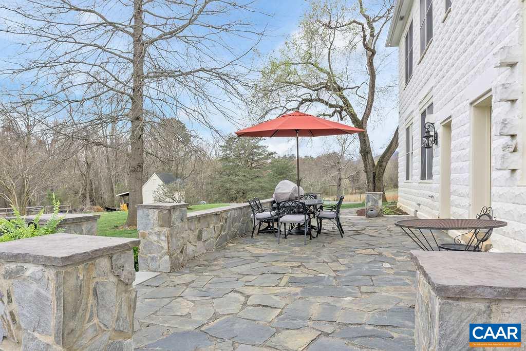 4543 Garth Road Charlottesville, VA 22901 - Photo 24 of 50 a view of a patio with a table and chairs under an umbrella