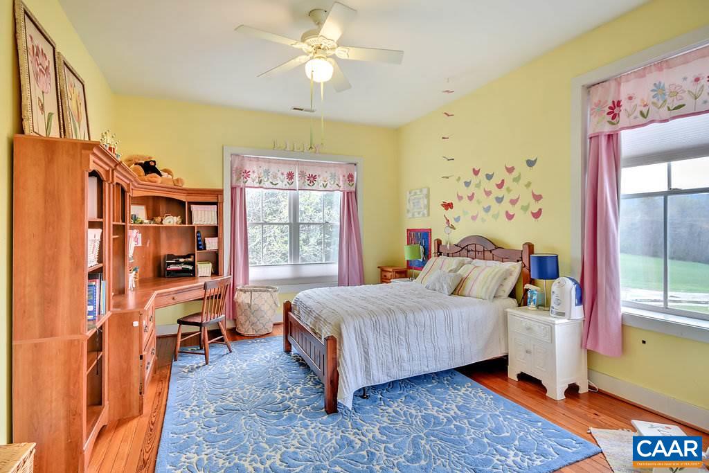 4543 Garth Road Charlottesville, VA 22901 - Photo 31 of 50 a bedroom with a bed a dresser and a large window