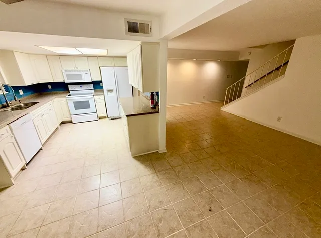 a view of a kitchen with furniture and an empty room