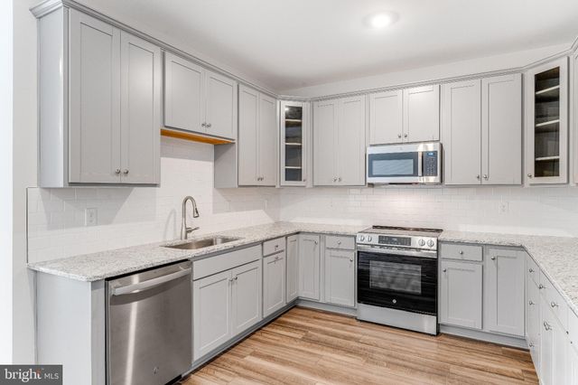 a kitchen with stainless steel appliances granite countertop a sink stove and cabinets