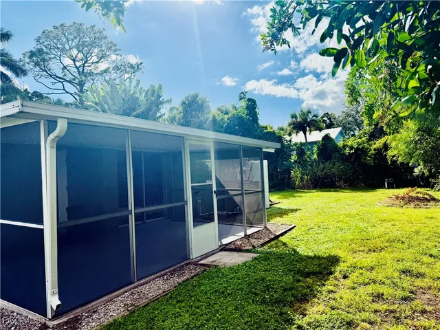 a view of a house with backyard and a tree