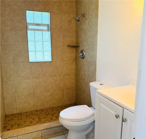 a white toilet sitting next to a shower