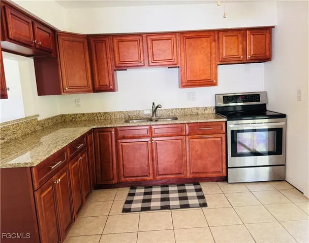 a kitchen with stainless steel appliances granite countertop a sink stove and cabinets