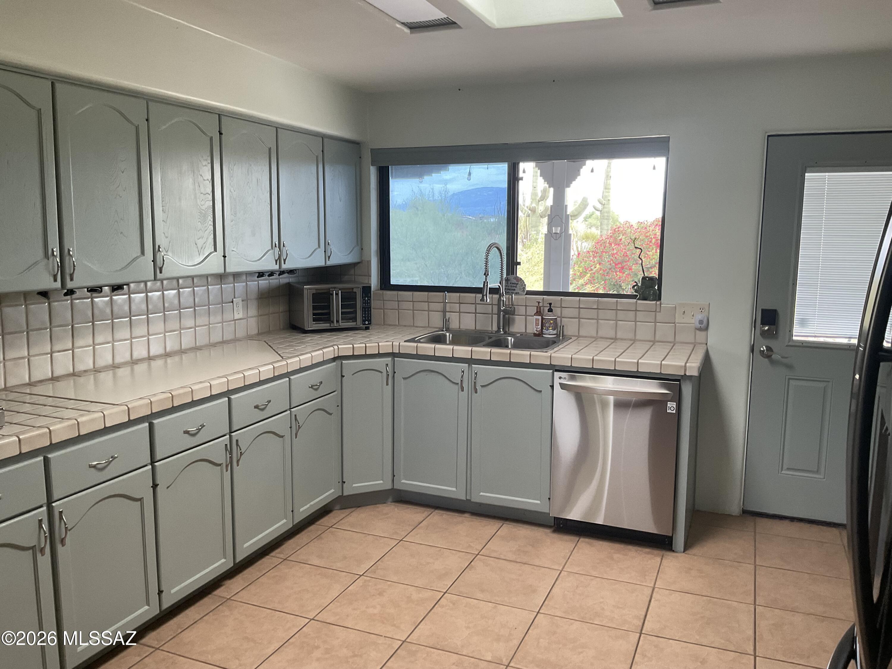 4060 North Swan Road Tucson, AZ 85718 - Photo 23 of 47 a kitchen with stainless steel appliances granite countertop a sink stove and cabinets