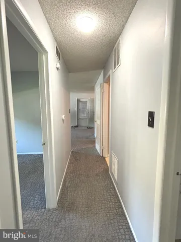 a view of an empty room with window and closet area