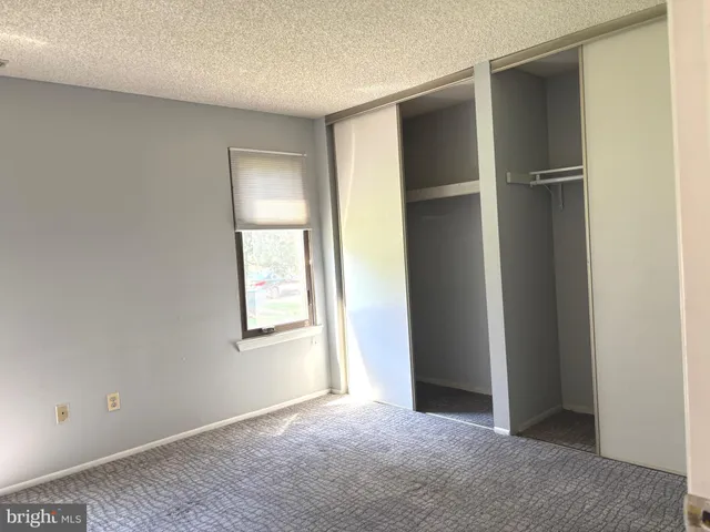 an empty room with windows and closet