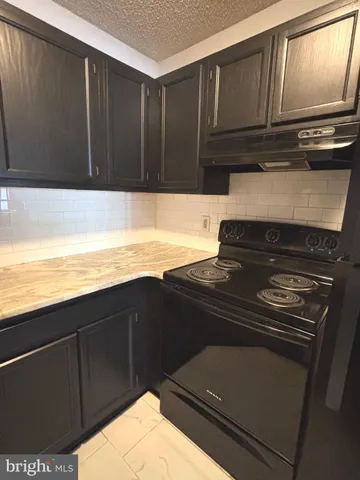 a kitchen with wooden cabinets and a stove top oven