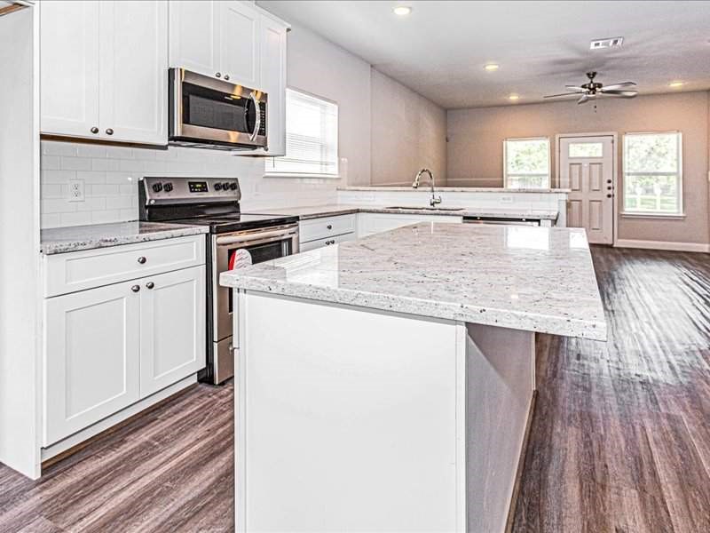 7838 Booker Street, Unit B Houston, TX 77028 - Photo 3 of 28 a kitchen with stainless steel appliances granite countertop a stove a sink and a microwave