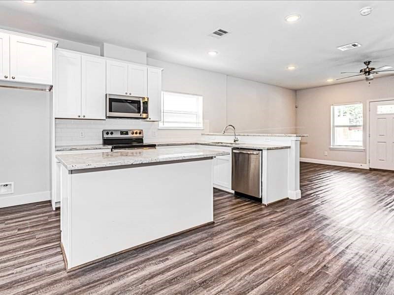 7838 Booker Street, Unit B Houston, TX 77028 - Photo 4 of 28 a kitchen with stainless steel appliances a white stove top oven sink and cabinets