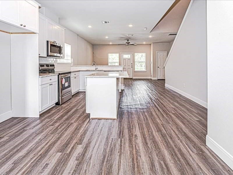 7838 Booker Street, Unit B Houston, TX 77028 - Photo 6 of 28 a kitchen with a refrigerator microwave and stove top oven