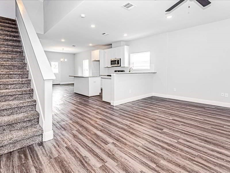 7838 Booker Street, Unit B Houston, TX 77028 - Photo 10 of 28 an empty room with wooden floor and kitchen view