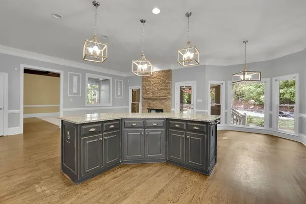 a kitchen with granite countertop a stove a sink and a wooden floor