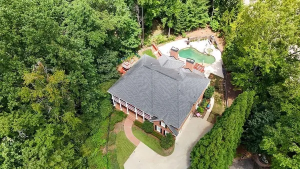 an aerial view of a house with a yard and large trees