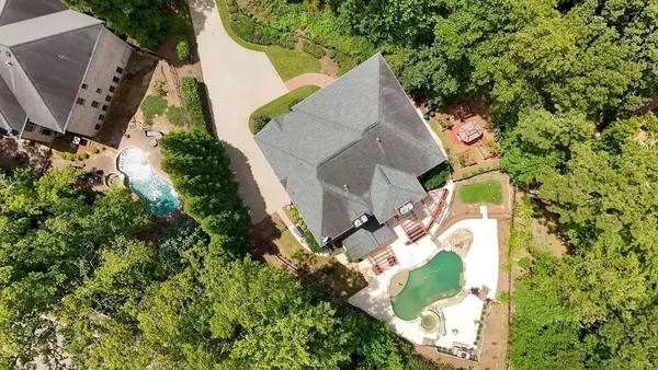 an aerial view of a house with a yard and trees