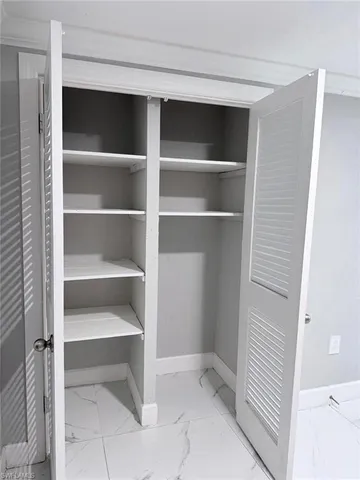 a view of walk in closet with empty racks