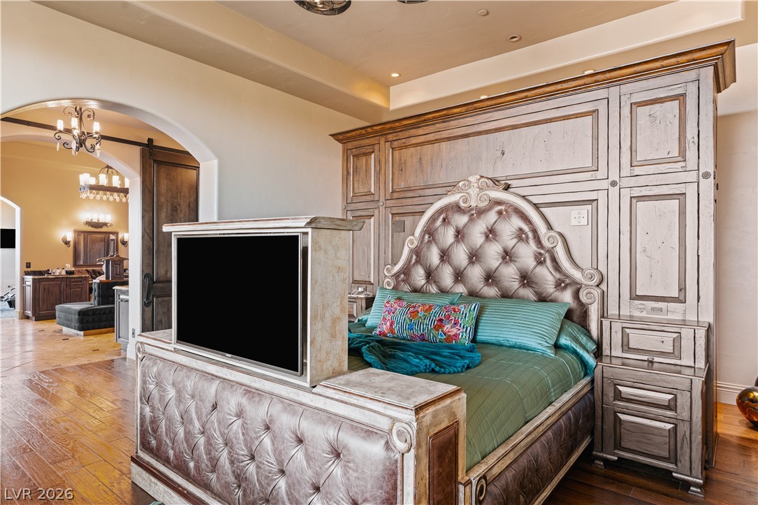 1123 Christian Road Henderson, NV 89002 - Photo 23 of 94 Ornate custom woodwork frames a bed with a luxurious tufted headboard in this inviting sleeping quarter.