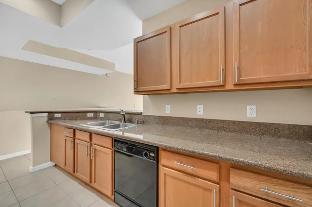 a kitchen with stainless steel appliances granite countertop a sink and a white cabinets