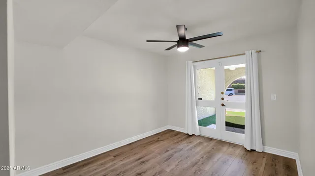 a view of a hallway with wooden floor and a bathroom