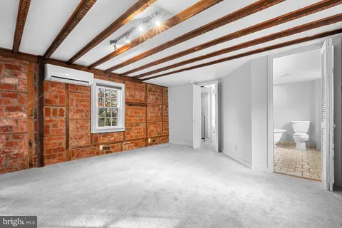 a spacious bedroom with a bed and a flat screen tv