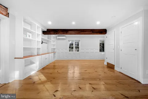 a view of empty room with wooden floor and windows