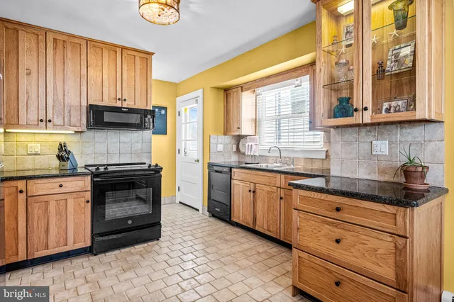 a kitchen with granite countertop wooden cabinets and a stove top oven