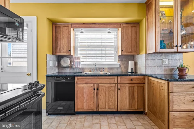 a kitchen with granite countertop a sink stove and cabinets