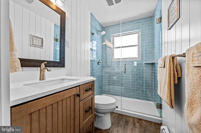 a bathroom with a sink a toilet and shower