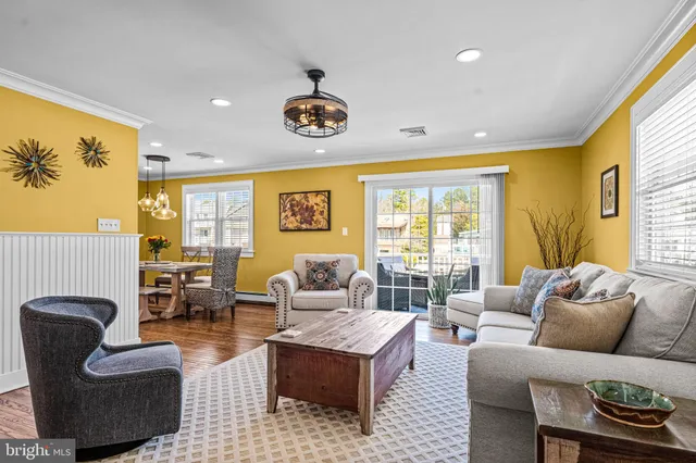 a living room with furniture ceiling fan and a large window
