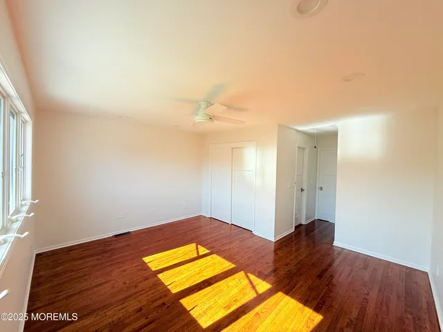a view of a room with wooden floor and a window