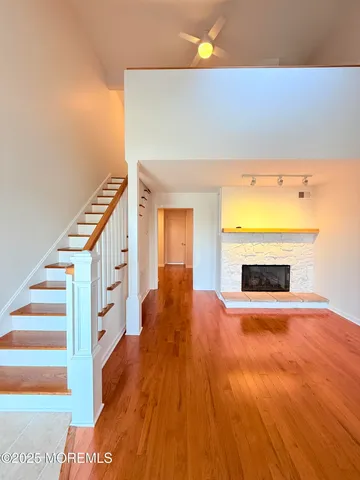 a view of a hallway with wooden floor and a fireplace