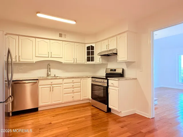 a kitchen with stainless steel appliances granite countertop a stove a sink and a refrigerator