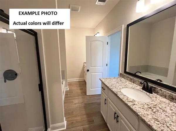 a bathroom with a granite countertop sink a mirror and shower
